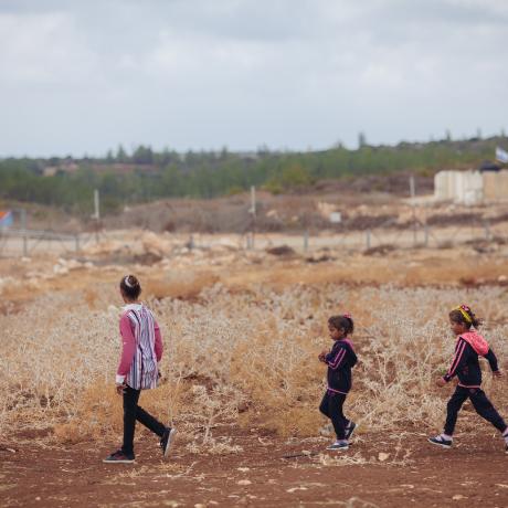 Ameera, 11, and her sisters walk along their farmland in the West Bank