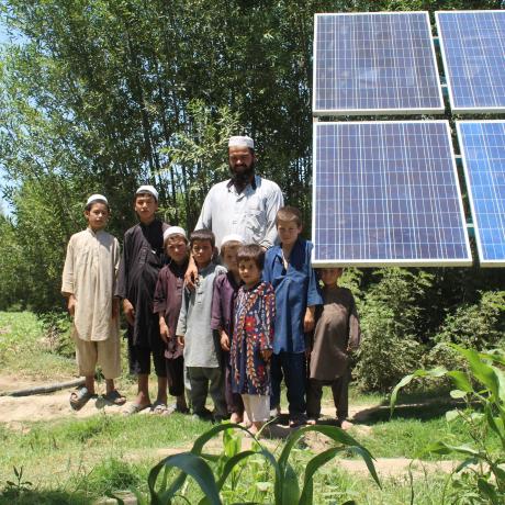 A family standing near a solar energy plant