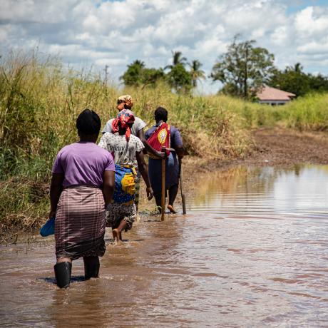 Women farmers walk through flooded fields in Buzi, Mozambique.