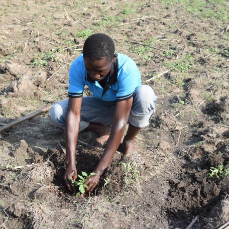 Okech practices his farming skills in Uganda